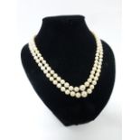 A twin strand cultured pearl necklace set with graduated pearls to a 9ct gold Amethyst set clasp,