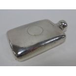 Silver hip flask with hammered decoration and twist and lift cap,