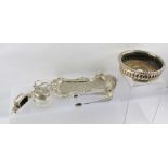 A PAIR OF SILVER PLATED SNUFFERS ON A TRAY, a plated BOTTLE COASTER with turned wood base, a pair of