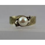 A PEARL AND DIAMOND DRESS RING, in modernist 14ct gold crossover setting, the central pearl