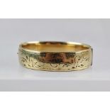 A 9CT GOLD METAL CORE BANGLE, with scroll decoration and snap clasp