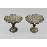 A PAIR OF WHITE METAL CONTINENTAL FILIGREE SWEETMEATS, of lobed form, raised on knopped stems, on