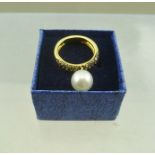 AN 18CT GOLD DESIGNER RING, set diamonds and pearl, of unusual form, the pearl mounted so that it