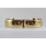 A 9CT GOLD BANGLE, having floral engraved decoration