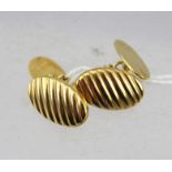 A PAIR OF SMALL 9CT GOLD CUFFLINKS of oval form with ridged decoration, 4g.