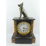 A GILT AND BLACK SLATE MANTEL TIMEPIECE, having cast metal Alsatian surmount, 34cm high (with