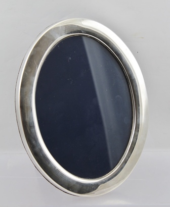 FRANCIS HOWARD AN OVAL SILVER PHOTOGRAPH FRAME having plain surround and blue velvet easel stand,