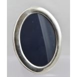 FRANCIS HOWARD AN OVAL SILVER PHOTOGRAPH FRAME having plain surround and blue velvet easel stand,