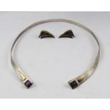 A SILVER TORC DESIGN NECKLACE, inset with cushion cut amethysts to the tips and yellow metal detail,