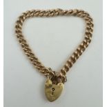 A 9CT. GOLD CURB LINK BRACELET with padlock, 21g.