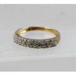 A DIAMOND HALF HOOP ETERNITY RING having three rows of pave set diamonds in white and yellow gold