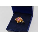 A 9CT GOLD LADY'S DRESS RING, inset with rubies etc., size M