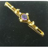 A VICTORIAN 15CT. GOLD BAR BROOCH set with amethyst and seed pearls, bears Chester hallmarks