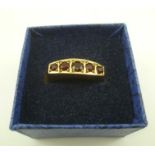 A 9CT. GOLD RING set with five graduated garnets, size P