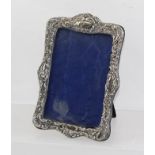 MARKS OBSCURED AN EDWARDIAN FANCY RECTANGULAR EMBOSSED SILVER PHOTOGRAPH FRAME with blue velvet