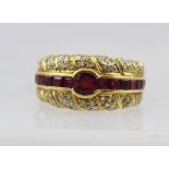 AN 18CT GOLD CONTEMPORARY DESIGN DRESS RING set with a band of rubies, flanked by bands of small