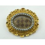 A VICTORIAN 18CT. GOLD MOURNING BROOCH, with central panel of plaited hair
