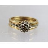 A LADY'S 9CT GOLD DIAMOND CLUSTER RING, having diamond shoulders, size N tight