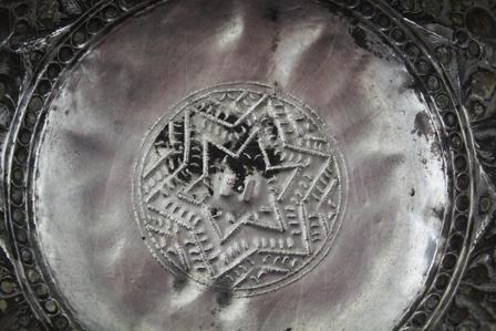 AN EASTERN WHITE METAL BOWL, having embossed decoration in the round of stylised flowers and praying - Image 4 of 6