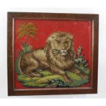 A LATE VICTORIAN WOOLWORK PANEL, depicting a lion couchant, in stylised landscape on a red ground,