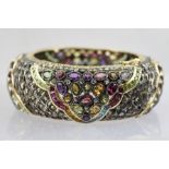 A MULTI STONE SET HEAVY BANGLE set with diamonds and other precious stones, set in 18ct gold