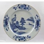 A CHINESE PORCELAIN PLATE circa 1800, having blue painted river landscape decoration with flowers to