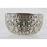 AN EASTERN WHITE METAL BOWL, having embossed decoration in the round of stylised flowers and praying