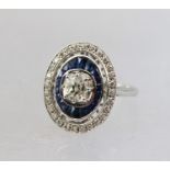 AN 18CT WHITE GOLD CLUSTER RING having large diamond central stone surrounded by sapphires, and a