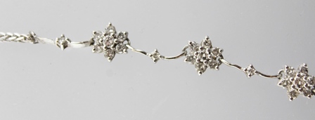 AN 18CT WHITE GOLD NECKLACE with nine diamond set flower heads interspersed by ten diamonds, total - Image 4 of 5