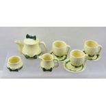 A MID 20TH CENTURY CHILD'S POTTERY PART TEASET, having cream glaze with green ribbon and bow