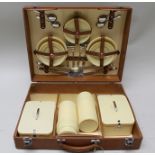 A "SIRRAM" PICNIC HAMPER, fitted for four people, with flasks, plates, etc., in a cream colour,