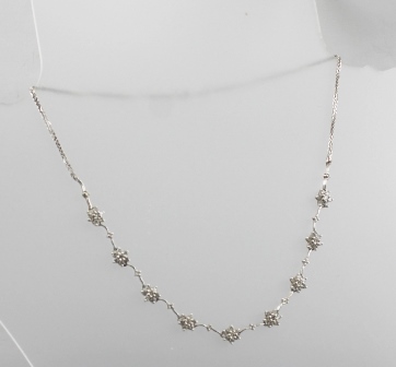 AN 18CT WHITE GOLD NECKLACE with nine diamond set flower heads interspersed by ten diamonds, total