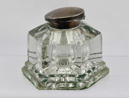 AN EARLY 20TH CENTURY GLASS INKWELL of hexagonal form with hinged silver cover. Birmingham 1930