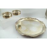 A SILVER PLATED SERVING TRAY with cast decorative edge, raised on four cast feet, 45cm diameter,