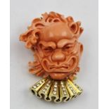 AN 18CT, DIAMOND AND CARVED CORAL PENDANT/BROOCH of Noh mask design, stamped "750"