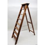 A "SLINGSBY" SET OF INDUSTRIAL STAINED WOOD SEVEN TREAD STEP LADDERS bearing original maker's name