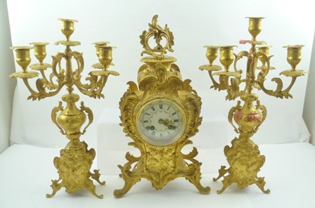 A LATE 19TH CENTURY GILT METAL FRENCH CLOCK GARNITURE GROUP, comprising the central clock, flanked