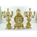 A LATE 19TH CENTURY GILT METAL FRENCH CLOCK GARNITURE GROUP, comprising the central clock, flanked