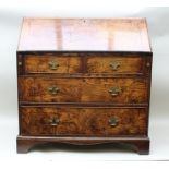 A GEORGE III OAK FALL-FRONT WRITING BUREAU, opening to reveal fitted interior, over two short and