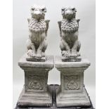 A PAIR OF RECONSTITUTED STONE HERALDIC SEATED GRIFFIN GARDEN STATUES, raised on plinth bases,