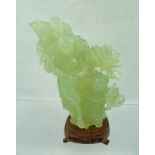 A CHINESE JADE CARVING, Bijin with companion, floral and tree trunk background, raised upon a