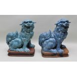 TWO CHING DYNASTY DESIGN TURQUOISE GLAZED TERRACOTTA SEATED TEMPLE DOGS OF FO on platform bases,