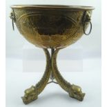 A 19TH CENTURY EMBOSSED BRASS PEDESTAL BOWL OR JARDINIERE with landscape panel decoration, with