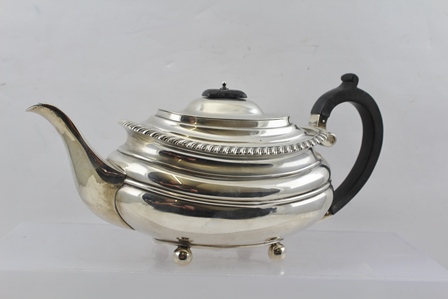 WILLIAM HUTTON & SONS LTD. AN EARLY 20TH CENTURY SILVER TEAPOT of Georgian design with gadrooned