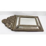 A LATE 19TH CENTURY BAROQUE DESIGN REPOUSSE METAL FRAMED WALL MIRROR of cushion form with decorative