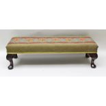 A LONG JOHN FOOTSTOOL, having wool work upholstered top, raised on carved cabriole supports, 93cm