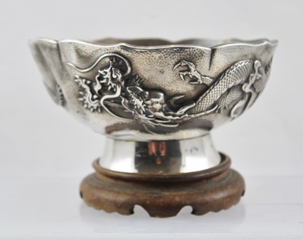 A CHINESE EXPORT SILVER BOWL, hammered finish with raised dragon design in the round, character mark