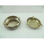 TWO ANGLO-INDIAN WHITE METAL ASHTRAYS with chased floral decoration, combined weight 156g.