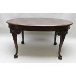 AN EDWARDIAN OVAL CROSSBANDED MAHOGANY DINING TABLE raised on carved cabriole supports with ball and