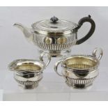 AN EARLY 20TH CENTURY SILVER THREE-PIECE TEA SET, of squat partially fluted form with scallop and